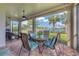 Covered lanai offering comfortable seating, ceiling fan, lush lake views with beautiful landscaping at 13334 Pacchio St, Venice, FL 34293
