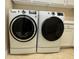 The laundry room has a white washer and dryer plus storage cabinets at 13334 Pacchio St, Venice, FL 34293