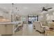 Open-concept living area with kitchen island, dining area, and serene lake views from sliding glass doors at 13334 Pacchio St, Venice, FL 34293
