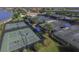 Aerial view of tennis courts in a beautiful community, featuring lush landscaping and shaded seating areas at 13334 Pacchio St, Venice, FL 34293