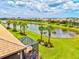 Aerial view of a backyard featuring lush lawn, mature landscaping, and lake views at 13913 Alafaya St, Venice, FL 34293