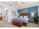 Bedroom with blue accent wall, natural light, ceiling fan, and wood furniture at 13913 Alafaya St, Venice, FL 34293