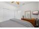Bright bedroom features a ceiling fan, closet, flatscreen television and neutral decor at 13913 Alafaya St, Venice, FL 34293