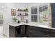 Stylish coffee bar with dark cabinets, quartz countertops, and a window view of the outdoors at 13913 Alafaya St, Venice, FL 34293
