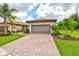Lovely home with a brick driveway, meticulously manicured lawn and lush landscaping at 13913 Alafaya St, Venice, FL 34293