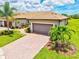 Charming home exterior with brick driveway, well-manicured landscaping, and a two-car garage at 13913 Alafaya St, Venice, FL 34293