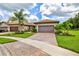 Beautiful home with a brick driveway and a well-manicured lawn and landscape at 13913 Alafaya St, Venice, FL 34293