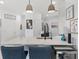 Bright kitchen with quartz countertop island, pendant lights and stylish barstool seating at 13913 Alafaya St, Venice, FL 34293