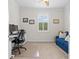 Carpeted office space features a desk, chair and blue sofa, all illuminated by natural light from the window at 13913 Alafaya St, Venice, FL 34293