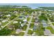 Community aerial view of homes, green landscape, and water with a white sandy beach at 1536 Porpoise Rd, Venice, FL 34293