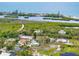Aerial photo highlights a neighborhood with well-maintained homes, mature trees, and stunning waterfront scenery in the background at 1536 Porpoise Rd, Venice, FL 34293