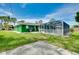 Spacious backyard featuring a screened-in pool, lush green lawn, and patio area for outdoor entertaining at 1536 Porpoise Rd, Venice, FL 34293