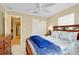 Comfortable bedroom features a ceiling fan, two windows, and wooden furniture at 1536 Porpoise Rd, Venice, FL 34293