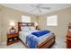Comfortable bedroom features a ceiling fan, two windows, and wooden furniture at 1536 Porpoise Rd, Venice, FL 34293