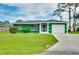 Charming green single-story home with manicured lawn and white trimmed windows and a white garage door at 1536 Porpoise Rd, Venice, FL 34293