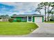 Exterior shot features a well-maintained lawn, an attached garage, and freshly painted exterior at 1536 Porpoise Rd, Venice, FL 34293