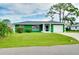 Charming home showcasing lush green lawn and beautiful, mature landscaping at 1536 Porpoise Rd, Venice, FL 34293