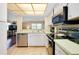 Well-lit kitchen with tile floors, stainless steel appliances, and a view into the living room at 1536 Porpoise Rd, Venice, FL 34293