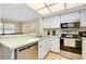 Bright kitchen featuring stainless appliances and bar seating, adjacent to the living room at 1536 Porpoise Rd, Venice, FL 34293