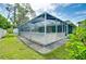 Exterior view of a screened-in pool with an adjacent green house, surrounded by mature trees at 1536 Porpoise Rd, Venice, FL 34293