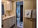 The bathroom features a vanity with cabinets, a sink, and a view of the toilet through the open doorway at 1608 E Cypress Point Dr, Venice, FL 34293