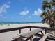 Scenic beach view from a picnic area with a wooden table and clear blue skies at 1608 E Cypress Point Dr, Venice, FL 34293