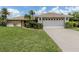 Charming single-story home with well-manicured lawn, mature landscaping, and a two-car garage at 1608 E Cypress Point Dr, Venice, FL 34293