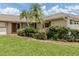 Lush green lawn and gardens lead to the front entrance at 1608 E Cypress Point Dr, Venice, FL 34293