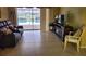 This living room has tile flooring, a slider to the pool, and comfortable seating at 1608 E Cypress Point Dr, Venice, FL 34293