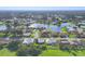 Aerial view of the property in a community with a lake and green lawns at 1614 Quail Lake Dr, Venice, FL 34293