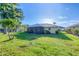 A spacious backyard features lush green grass and a screened-in lanai at 1614 Quail Lake Dr, Venice, FL 34293