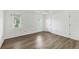 Sunny bedroom with light wood-look floors, white walls, and two windows for ample natural light at 1614 Quail Lake Dr, Venice, FL 34293