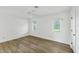 Spacious bedroom with wood-look floors, neutral walls, and dual windows for natural light at 1614 Quail Lake Dr, Venice, FL 34293
