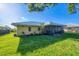 Rear exterior view showcasing screened in lanai and verdant landscaping at 1614 Quail Lake Dr, Venice, FL 34293
