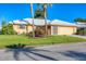 Charming single-story home featuring a well-manicured lawn, mature palms, and a light-colored tile roof at 1614 Quail Lake Dr, Venice, FL 34293