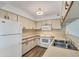 Efficient kitchen design with white appliances, wood-look flooring, and ample cabinet storage space at 1614 Quail Lake Dr, Venice, FL 34293
