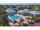 Beautiful community pool with tropical umbrellas, tennis court, and recreation center at 1614 Quail Lake Dr, Venice, FL 34293