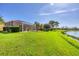 Expansive backyard with lush green lawn and picturesque water views at 1620 San Silvestro Dr, Venice, FL 34285