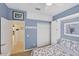Comfortable bedroom with blue walls, closet, and doorway leading to another room of the house at 1620 San Silvestro Dr, Venice, FL 34285