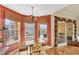 A sunny dining area with decorative chandelier and water views from multiple windows at 1620 San Silvestro Dr, Venice, FL 34285