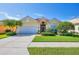 Charming home featuring manicured lawn, beautiful palms, tile roof and an attached two car garage at 1620 San Silvestro Dr, Venice, FL 34285