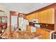 Bright kitchen featuring wood cabinetry, granite countertops, and white appliances at 1620 San Silvestro Dr, Venice, FL 34285