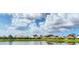 Scenic lake view showcasing the surrounding neighborhood, with a blue sky at 1620 San Silvestro Dr, Venice, FL 34285