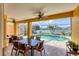 Outdoor patio with dining table and chairs offering a view of the pool and lake at 1620 San Silvestro Dr, Venice, FL 34285