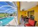 Spacious covered patio with dining and lounging areas, overlooking a sparkling pool and water view at 1620 San Silvestro Dr, Venice, FL 34285