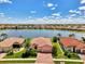 Beautiful aerial view of a lakeside home with a brick driveway, manicured lawn, and a tranquil lake view at 20370 Grazie Pl, Venice, FL 34293