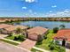 Lakeside home showcasing brick driveway, well-manicured lawn and professional landscaping with stunning water view at 20370 Grazie Pl, Venice, FL 34293
