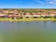 Aerial view of a community with a central lake, showcasing tile roofs, landscaping, and waterfront homes at 20370 Grazie Pl, Venice, FL 34293