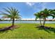 Backyard with lawn, palms, and a stunning lake view at 20370 Grazie Pl, Venice, FL 34293