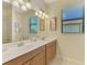 Bathroom featuring a double sink vanity with a large mirror and modern lighting fixtures at 20370 Grazie Pl, Venice, FL 34293